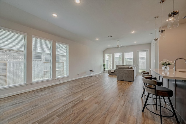 living area with light wood finished floors, recessed lighting, visible vents, a ceiling fan, and baseboards