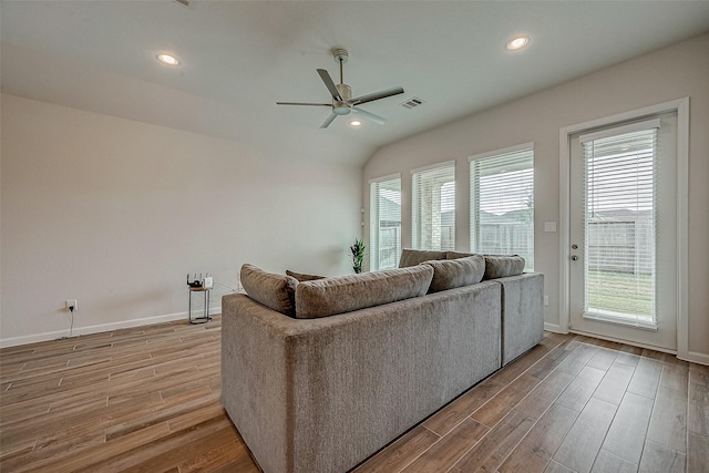 living room with wood-type flooring, ceiling fan, and vaulted ceiling