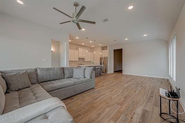 living area featuring light wood finished floors, a ceiling fan, visible vents, and recessed lighting