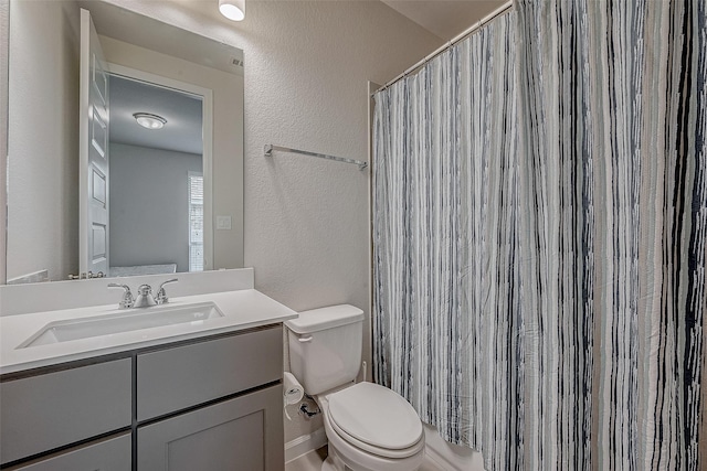 bathroom with toilet, vanity, a shower with shower curtain, and a textured wall