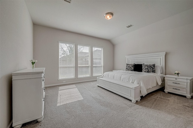 bedroom featuring lofted ceiling, visible vents, and carpet flooring