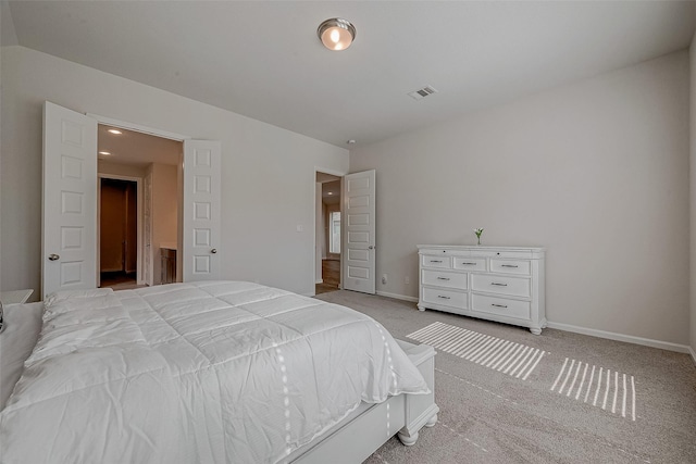 bedroom with baseboards, visible vents, and light colored carpet