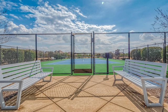 view of sport court with a gate and fence