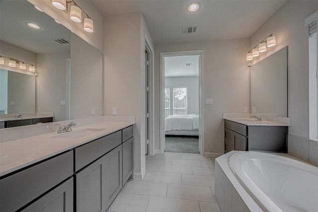 ensuite bathroom featuring two vanities, a sink, visible vents, and tile patterned floors