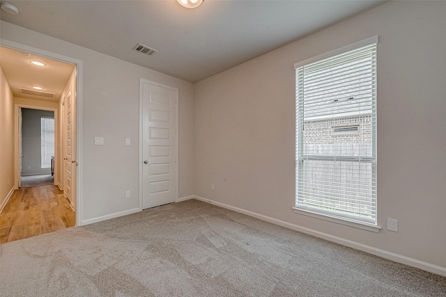 empty room featuring baseboards, visible vents, and carpet flooring