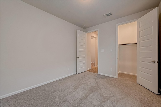 unfurnished bedroom with light carpet and a closet