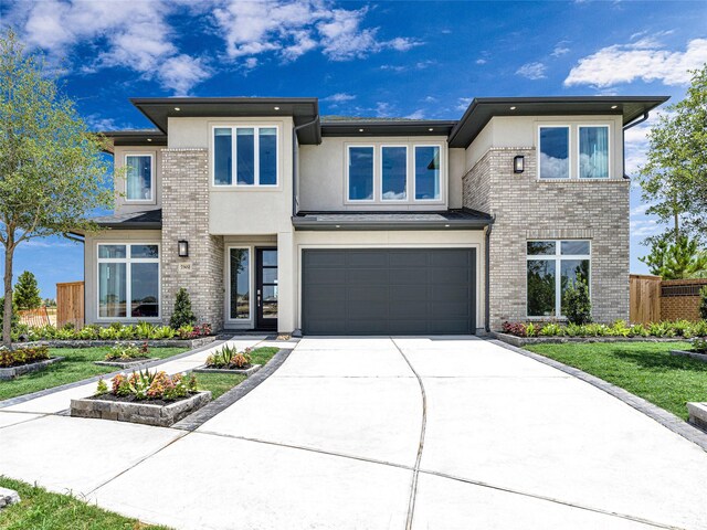 prairie-style house featuring a garage and a front yard