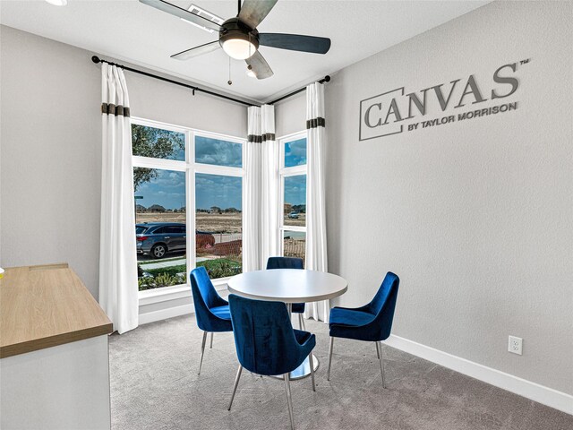 carpeted dining room featuring ceiling fan