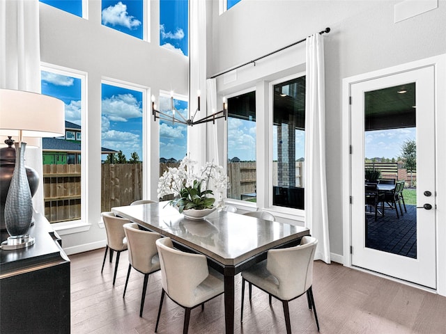 dining area featuring hardwood / wood-style flooring and a towering ceiling