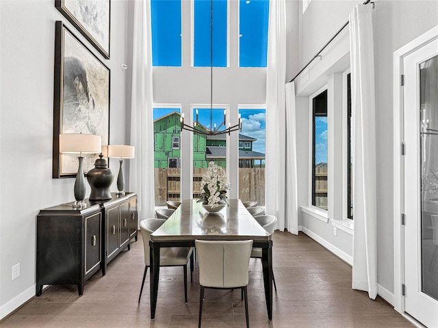 dining area featuring hardwood / wood-style flooring and a towering ceiling