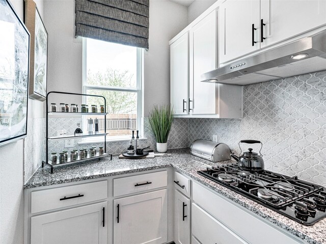 kitchen with white cabinetry, black gas cooktop, light stone counters, and decorative backsplash