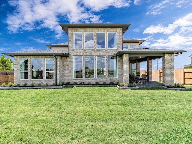 back of house with a yard and a patio