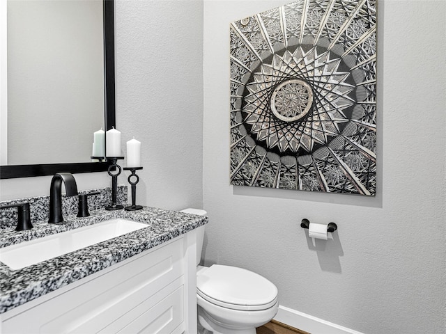 bathroom with vanity, toilet, and wood-type flooring