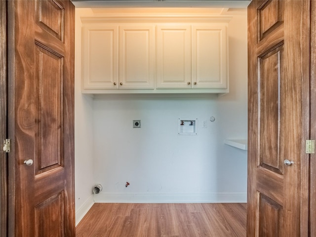 laundry area with gas dryer hookup, cabinets, light hardwood / wood-style flooring, electric dryer hookup, and washer hookup