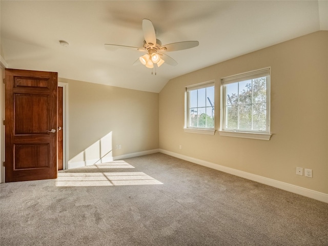 empty room featuring lofted ceiling, light carpet, and ceiling fan