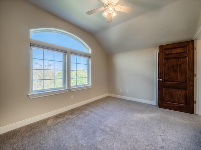 carpeted spare room featuring lofted ceiling and ceiling fan