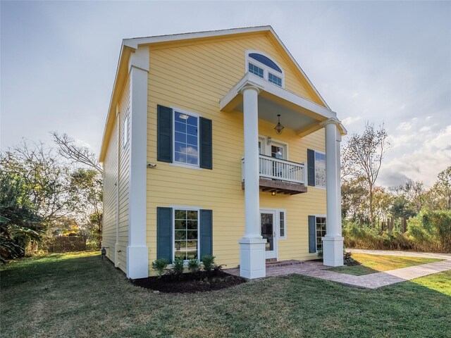 view of front of property featuring a front lawn and a balcony