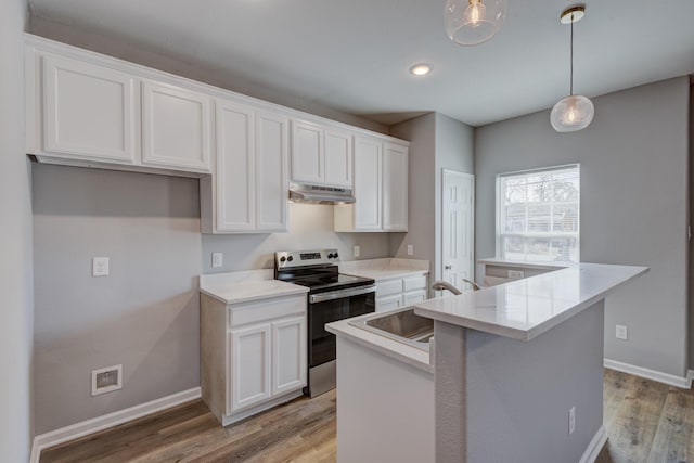 kitchen with stainless steel electric stove, sink, white cabinets, hanging light fixtures, and a center island with sink