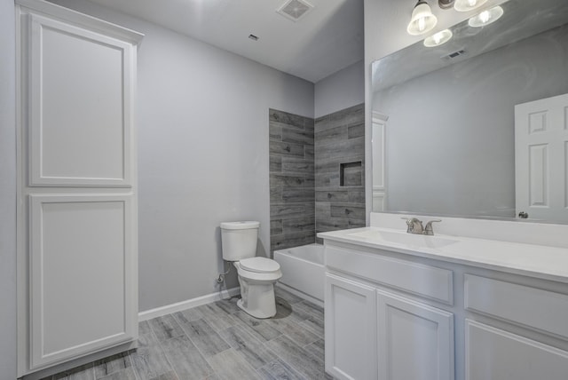 full bathroom featuring tiled shower / bath, vanity, and toilet