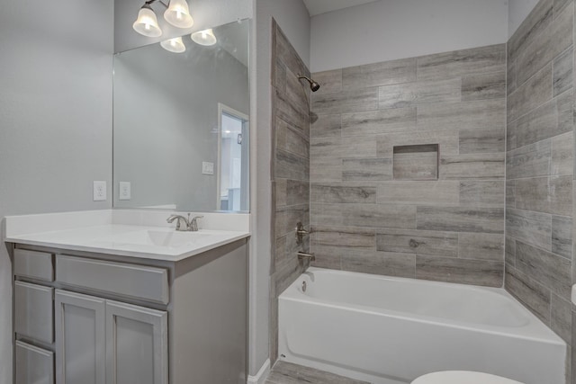 full bathroom with vanity, tiled shower / bath combo, and toilet