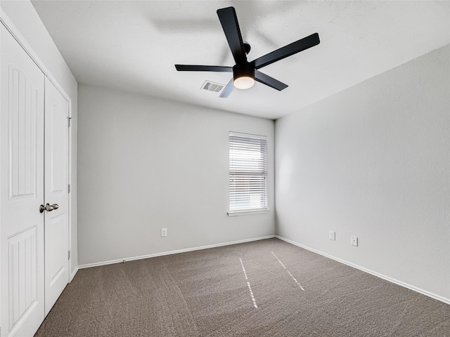 unfurnished bedroom featuring ceiling fan and dark colored carpet