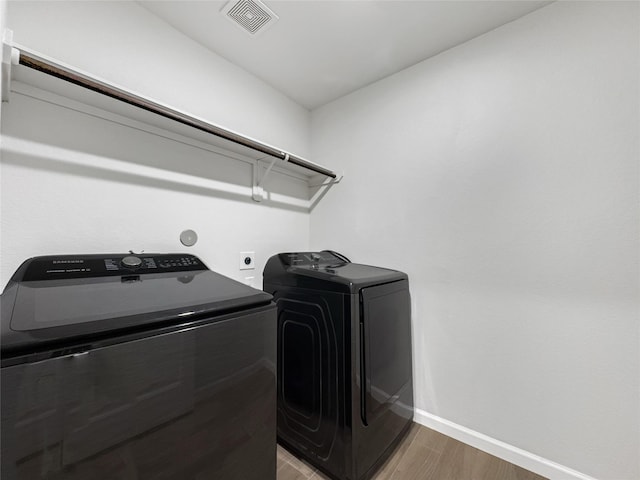 laundry area featuring hardwood / wood-style flooring and washer and clothes dryer