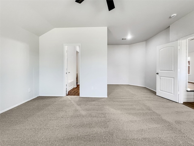 empty room featuring lofted ceiling, carpet floors, and ceiling fan