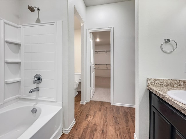 full bathroom with vanity, wood-type flooring, toilet, and washtub / shower combination