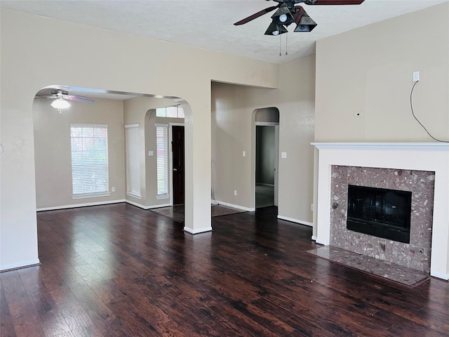 unfurnished living room featuring dark hardwood / wood-style flooring, a textured ceiling, a fireplace, and ceiling fan