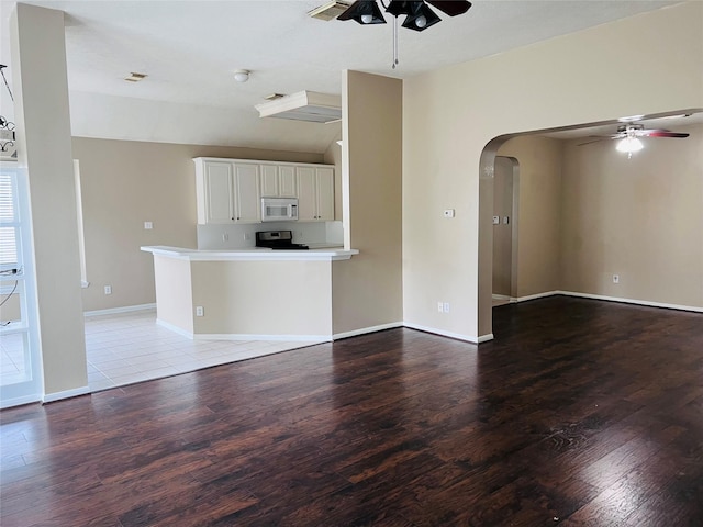 unfurnished living room with ceiling fan, vaulted ceiling, and light wood-type flooring