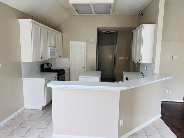 kitchen featuring stainless steel gas stove, kitchen peninsula, and white cabinets