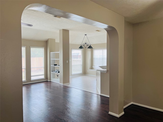 unfurnished dining area with dark hardwood / wood-style floors, a textured ceiling, and a wealth of natural light