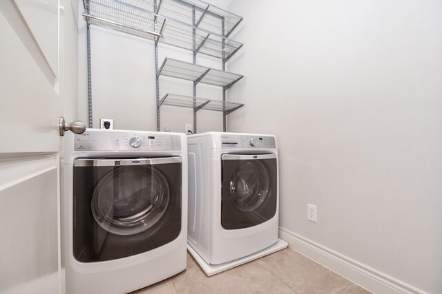 washroom featuring light tile patterned flooring and washing machine and clothes dryer