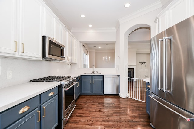 kitchen featuring high end appliances, sink, white cabinetry, and blue cabinets