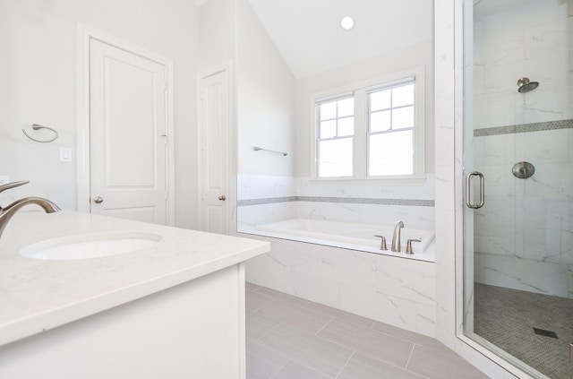 bathroom featuring vanity, shower with separate bathtub, and vaulted ceiling