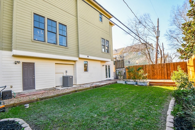 rear view of property featuring a yard and central AC unit