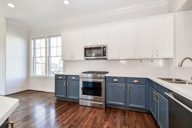 kitchen with blue cabinets, sink, white cabinets, stainless steel appliances, and crown molding