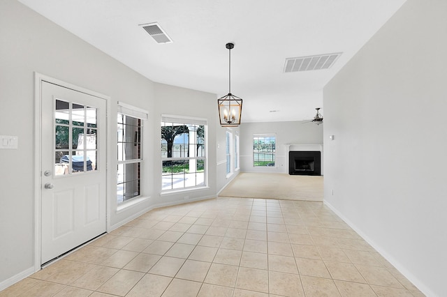 foyer featuring ceiling fan with notable chandelier and light tile patterned floors