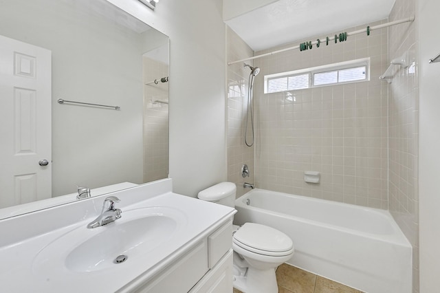 full bathroom with tile patterned flooring, tiled shower / bath, vanity, and toilet