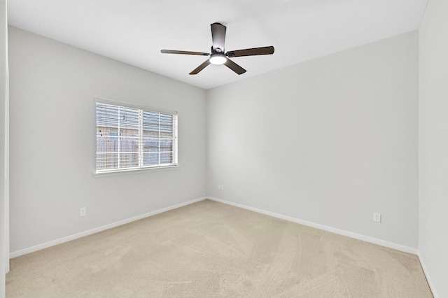 empty room featuring light colored carpet and ceiling fan