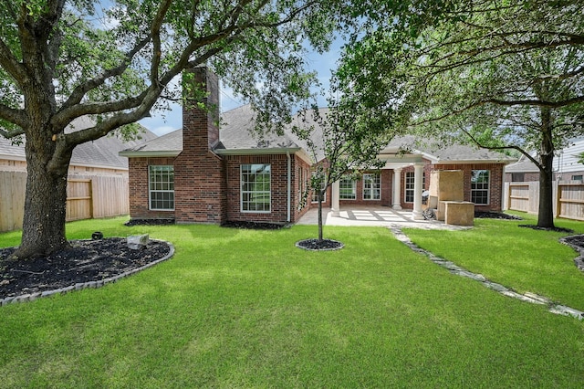 back of property with a yard and a patio