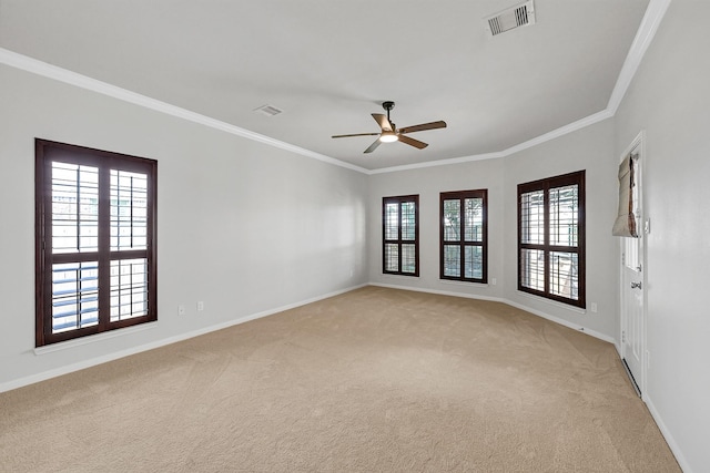 carpeted spare room with ceiling fan and ornamental molding