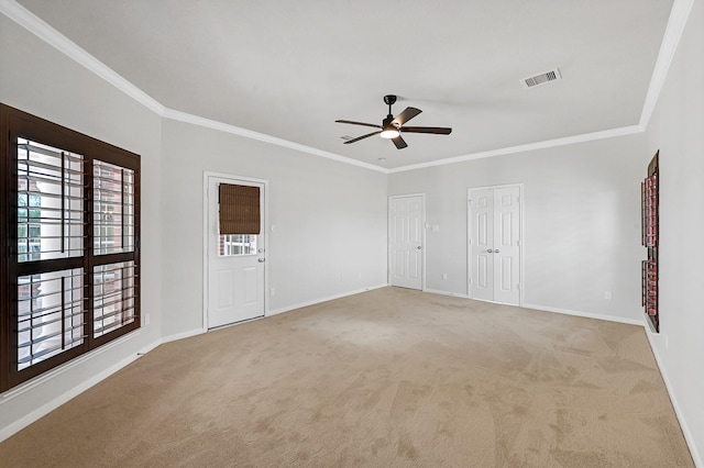 carpeted spare room featuring crown molding and ceiling fan