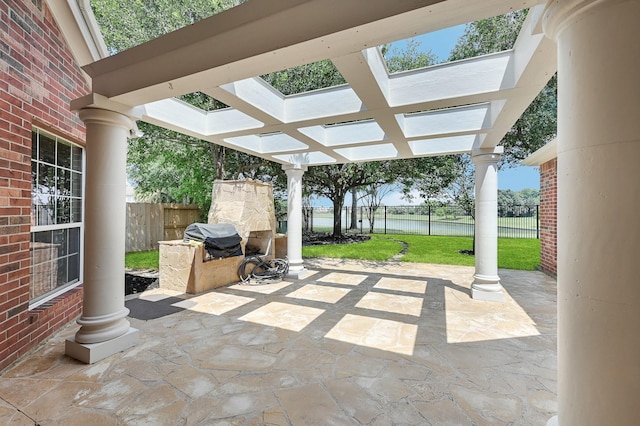 view of patio featuring exterior kitchen, a water view, and grilling area