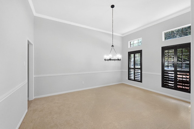 spare room with crown molding, a chandelier, and carpet flooring