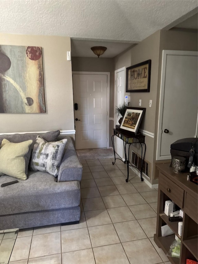 tiled living room featuring a textured ceiling