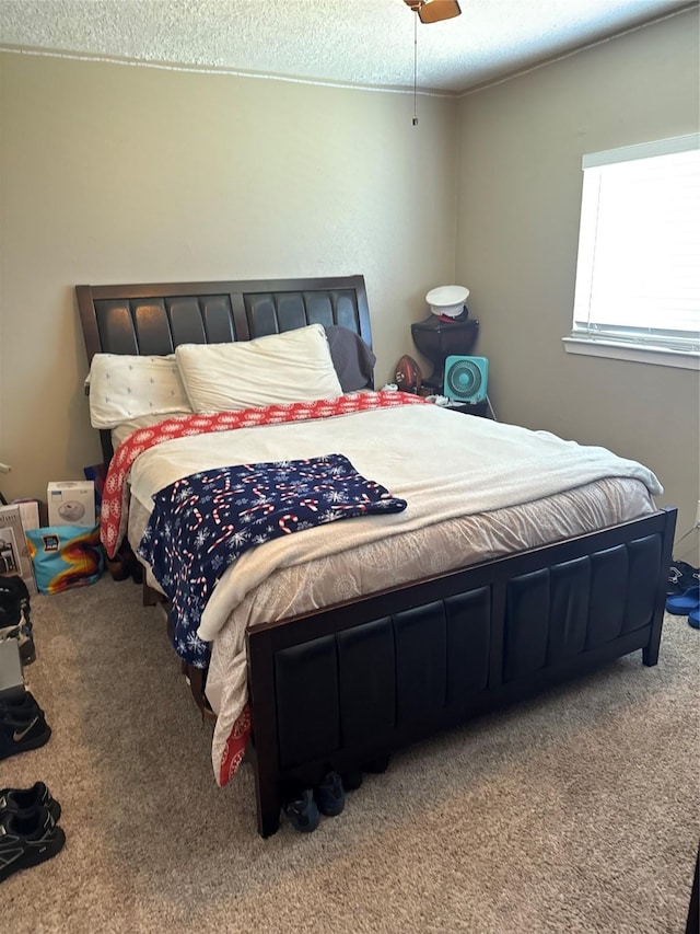 bedroom featuring ceiling fan, carpet flooring, and a textured ceiling