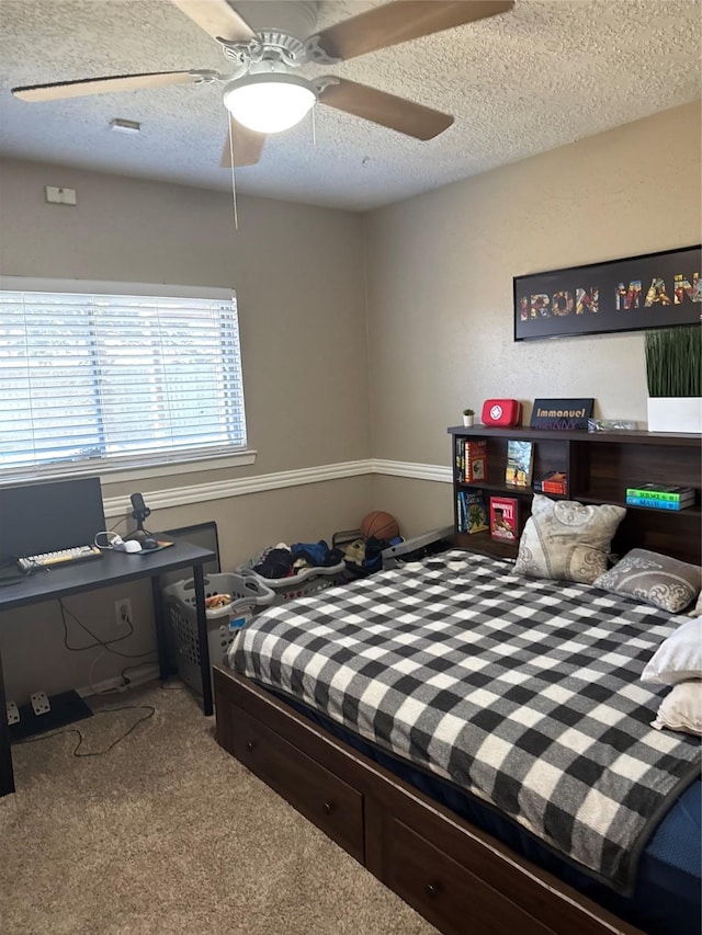 bedroom with ceiling fan, a textured ceiling, and carpet