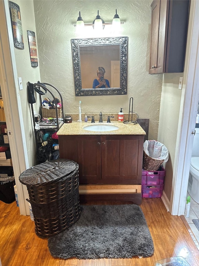 bathroom featuring vanity, hardwood / wood-style floors, and toilet