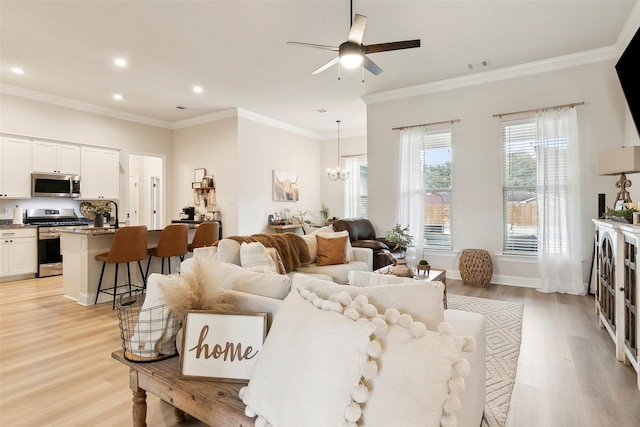 living room featuring crown molding, ceiling fan with notable chandelier, and light hardwood / wood-style floors